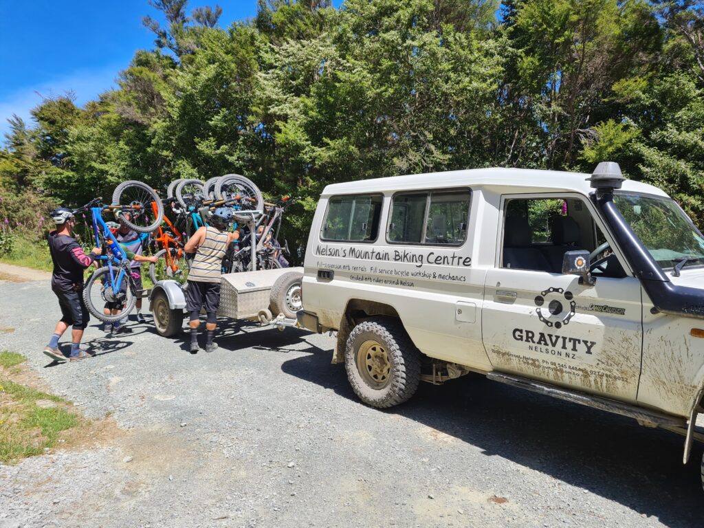 Mountain Bike Shuttle passengers unloading their bikes at the top of Fringed Hill.