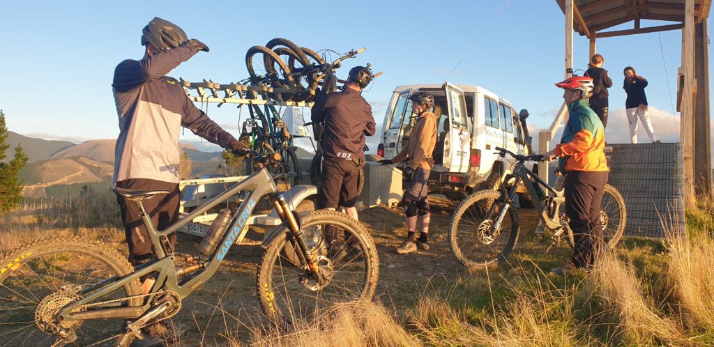 Sunset picture of mountain bikers getting out of a 4x4 mountain bike shuttle truck.